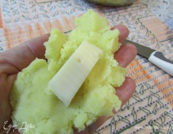Из картофельного пюре сделать лепёшку. В середину положить кусочек сыра.