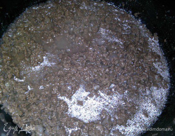 В раскаленном масле слегка пассеруем лук, добавляем фарш и обжариваем. Солим, перчим, добавляем мелко порезанный чеснок, обжариваем еще несколько минут и доливаем немного воды, тушим, пока вода не выпарится.