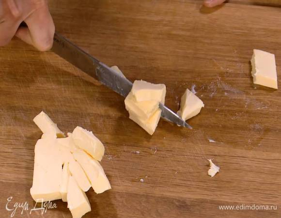 Предварительно охлажденное сливочное масло нарезать небольшими кусочками.