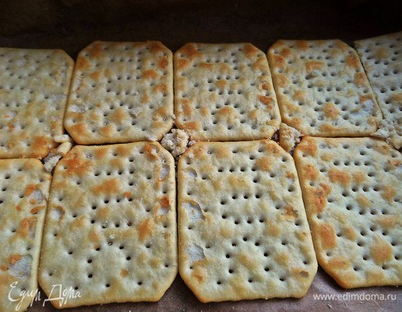 Крекеры укладываем на дно формы с пергаментом. У меня по 4,5 шт. в 2 ряда.