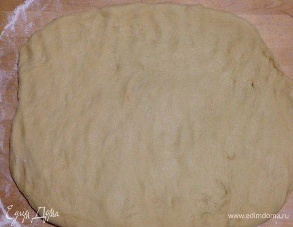 Достаем тесто из миски кладем на стол присыпанный мукой и руками его распластаем, как на фото.