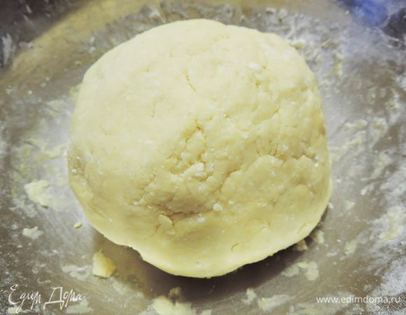 Постепенно добавить просеянную с содой муку и замесить мягкое тесто. Количество муки может немного варьироваться в зависимости от влажности творога и размера желтков.