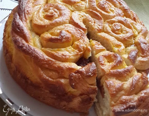 Выложить начинку. Украсить оставшимся тестом. Смазать желтком, смешанным с сахаром. Выпекать при 180°C около 50-60 минут.