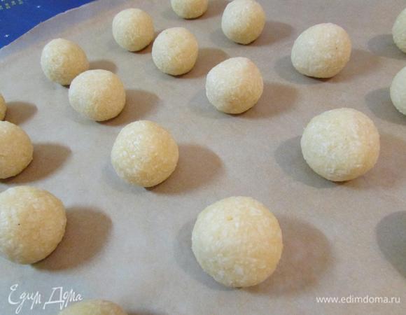 Можно формовать печеньки. Можно это делать влажными руками. У меня 26 кокосовых шарика, по 25 г. Выложить печенье на противень, застеленный пекарской бумагой.