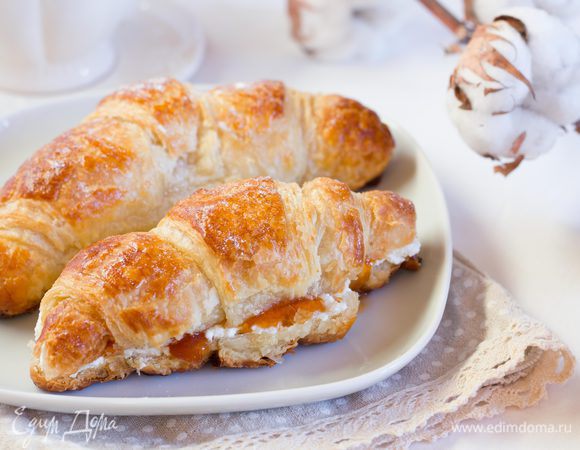 Готовые круассаны остудите. Разрежьте вдоль пополам, смажьте половину творожным кремом и сверху добавьте абрикосовый конфитюр (или любое любимое варенье) и накройте другой половинкой. Посыпьте круассаны сахарной пудрой.