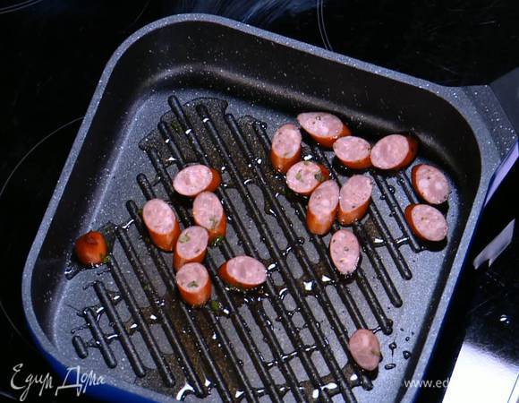 Разогреть в сковороде гриль оливковое масло и обжаривать кусочки колбаски до появления золотистой корочки.