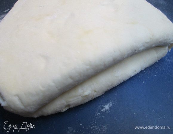 Через 12 часов достаем тесто из холодильника, даем немного согреться и раскатываем его, свернув его сначала в три слоя, т.е. делим тесто мысленно на три части, укладываем один край до середины пласта и сверху накрываем другим. Раскатываем снова в пласт, приблизительно 40х50.
Затем складываем тесто 2 раза пополам (в четыре слоя) — и снова раскатываем.