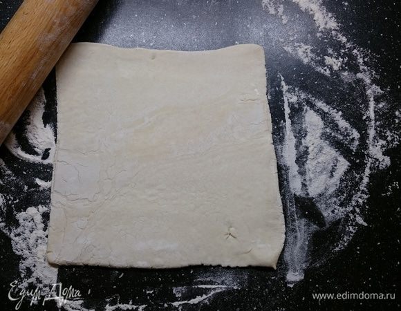 Слоеное тесто разморозить при комнатной температуре. Подпылив стол мукой, чтобы тесто не прилипало, немного раскатать пласт.