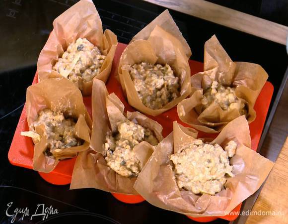 Формы для маффинов выстелить кусочками бумаги для выпечки, так чтобы края свешивались, и разложить в них тесто.