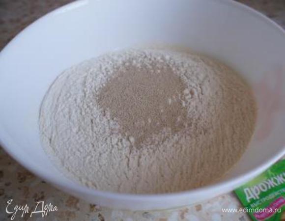 Муку просеять (1 столовую ложку отложить) и смешать с дрожжами.