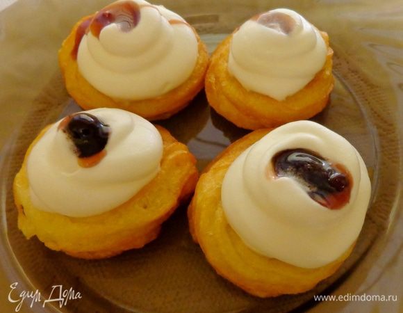 Взбить сливки и заполнить ими серединки печенья. Украсить вишневым джемом.