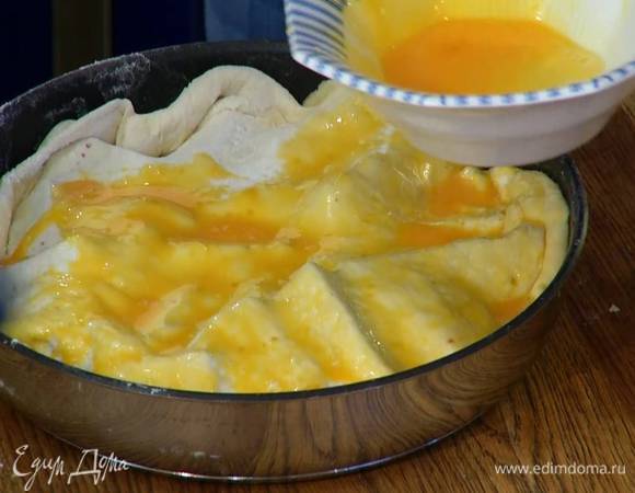 Желтки посолить, перемешать с молоком и кисточкой смазать тесто.