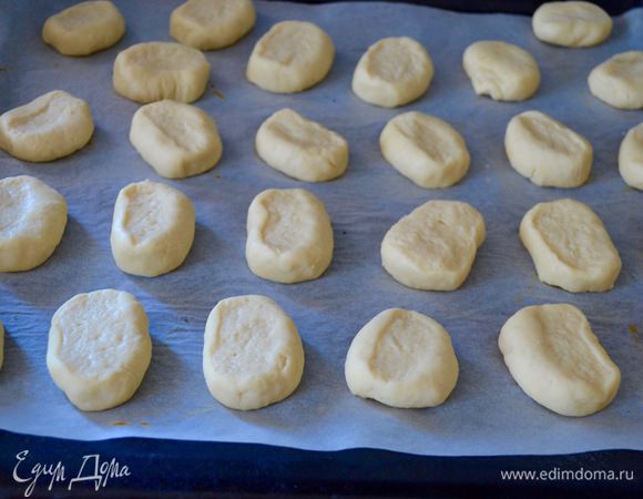 Каждый кусочек теста слегка приплюснуть и выложить на застеленный пекарской бумагой противень на небольшом расстоянии друг от друга. 