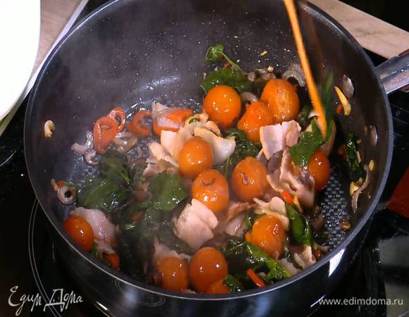 Бекон нарезать небольшими кусочками, добавить в сковороду с помидорами и шпинатом, перемешать и обжарить.