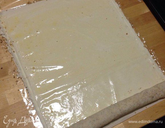 Теперь второй лист промазываем сливочным маслом и в начало кладем уже свернутый рулет, сворачиваем рулет со вторым листом, который промазан только маслом.
И тогда у вас получится рулет из двух листов теста фило, один будет с маслом и орехами, а второй просто с маслом .