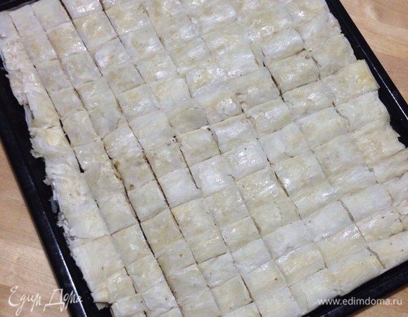 Потом все полученные рулеты укладываем на противень, смазываем обильно оставшимся маслом и разрезаем на порционные кусочки. 
Ставим в разогретую духовку при 180-200°C и выпекаем минут 35-45 до золотистого цвета.