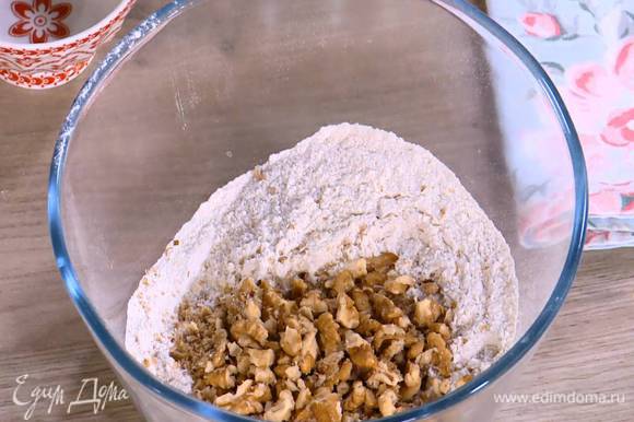 Грецкие орехи слегка измельчить в ступке и добавить к муке со специями.