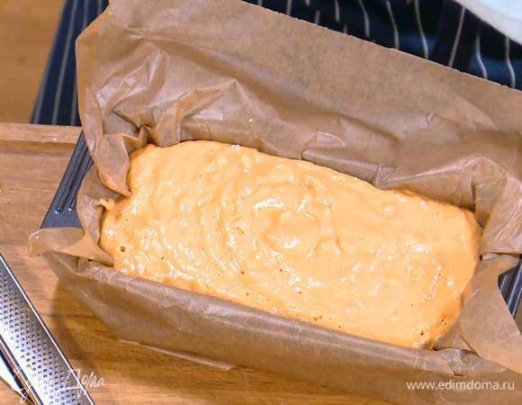 Продолговатую форму для выпечки выстелить пищевой бумагой и выложить тесто.