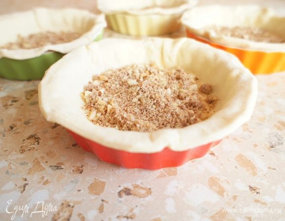 Посыпать тесто молотым миндалем, благодаря которому, лишняя жидкость, образованная из начинки, впитается в орехи и не размочит нашу основу из теста.