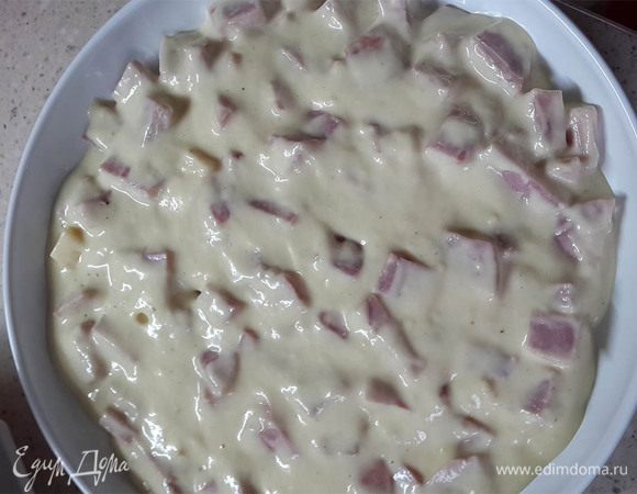 Выложить ветчину с сыром на блюдо для запекания. Сверху вылить смесь.