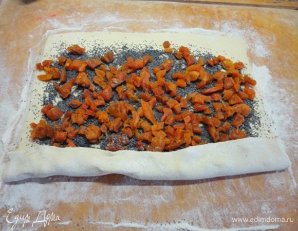 Раскатать тесто прямоугольником. Равномерно распределить мак и курагу. Свернуть рулетом.