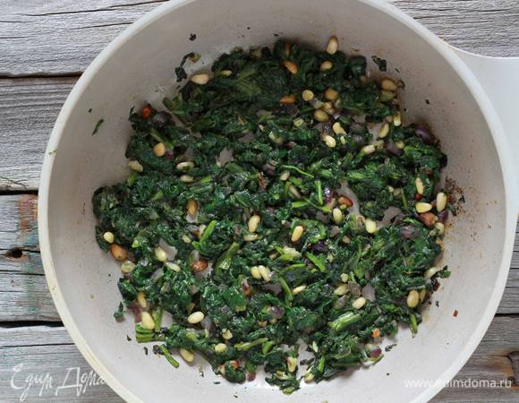Разогреть в сковороде оливковое масло и тушить шпинат вместе с кедровыми орехами пару минут, затем поперчить, посолить и снять с огня. Остудить.