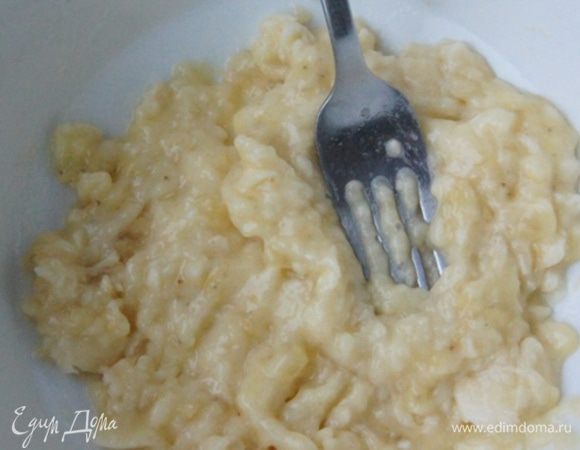 Духовку разогреть до 190°C. Лист застелить бумагой для выпечки. Банан размять вилкой. 