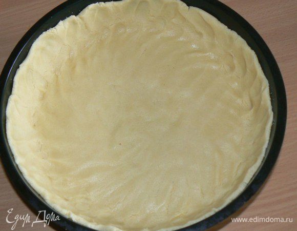 Духовку нагреть до 180°С.
Тесто вынуть из холодильника, раскатать на бумаге для выпечки, толщиной около 5 мм. В форму для выпечки диаметром около 18-20 перенести тесто. Поместить снова в холодильник, пока готовим начинку.