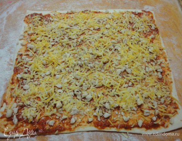 Тесто раскатать, смазать соусом, посыпать орехами и сыром.