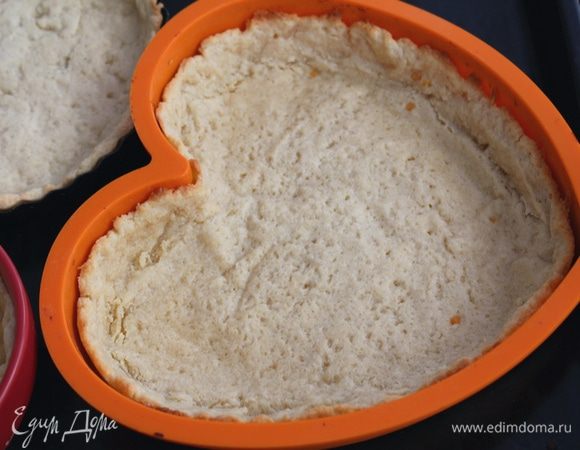 На тесто положить бумагу для выпечки, насыпать горох (или другой груз) и выпекать при 200°С 10 минут. Убрать горох и бумагу, выпекать еще 5 минут.