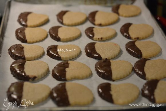 Окунать каждое готовое печенье в шоколад на небольшую часть. Выкладывать на противень с бумагой для выпечки дав подсохнуть или ставим в морозильник на 10 минут.