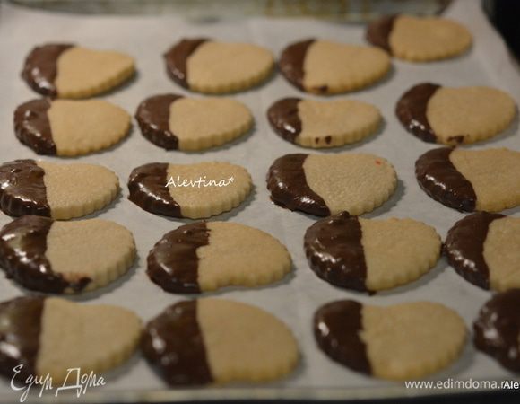 Окунать каждое готовое печенье в шоколад на небольшую часть. Выкладывать на противень с бумагой для выпечки дав подсохнуть или ставим в морозильник на 10 минут.