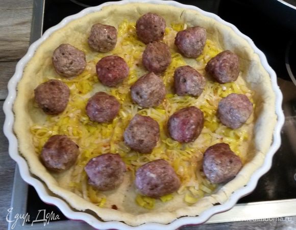 Далее на пирог выкладываем лук-порей и фрикадельки.