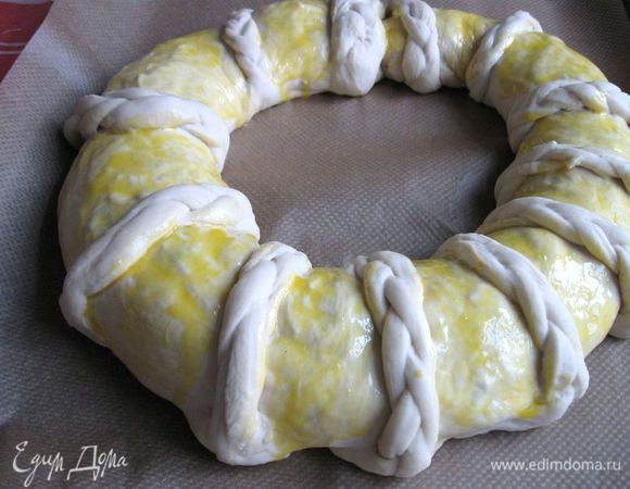 Смазать кисточкой желтком, смешанным с молоком, промежутки из гладкой части теста, минуя косички. Можете, конечно, и косички смазать желтковой смесью. Как вам больше нравится.