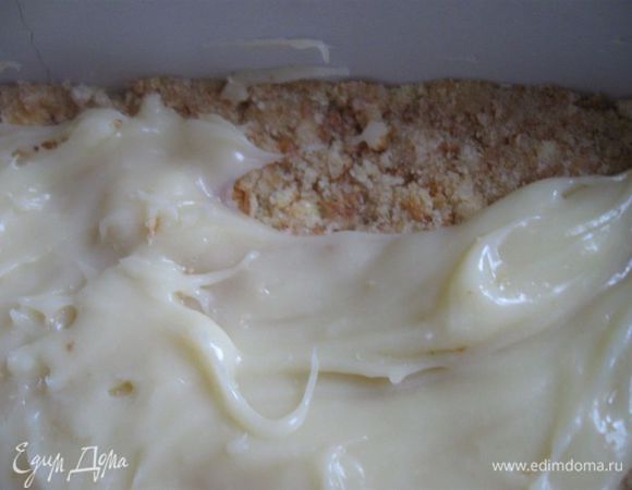 Дать крему полностью остыть, выложить его равномерно на основу из бисквитного печенья, поместить в холодильник на 30-40 минут.