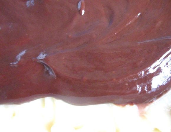 Поломать шоколад на кусочки, растопить со сливками на маленьком огне, помешивая, слегка остудить и полить шоколадным кремом сверху крема из сгущенного молока, распределив равномерно по поверхности. Убрать в холодильник на 5-6 часов минимально. Аккуратно порезать кубиками со стороной 2,5 см, можно чуть меньше.
