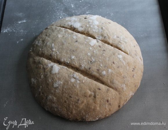 Прогреть духовку на 250-260°С. Перед посадкой в печь хлеб выложить швом вниз на пергамент, делаем пару параллельных надрезов и помещаем в разогретую духовку, ставим чашку воды. Закрываем дверцу и сразу снижаем температуру до 230°С. Через 10 минут пар выпускаем. Выпекаем хлеб еще 35-40 минут.
