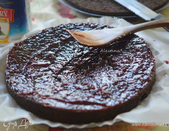 Бисквит после вылежки разрезать на 2 части. Смазать нижнюю часть обильно густым покупным или домашним малиновым джемом, или вишневым. Отставить в сторону.