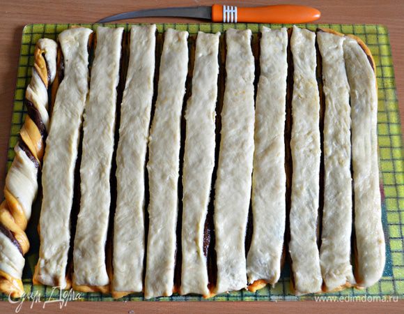 Сложить друг на друга все 3 пласта, слегка примять руками. Разрезать тесто роликом с фигурным ножом или просто ножом на полоски и скрутить три слоя теста спиралью (кликните на фото, и будет видно слева, как это сделать).
