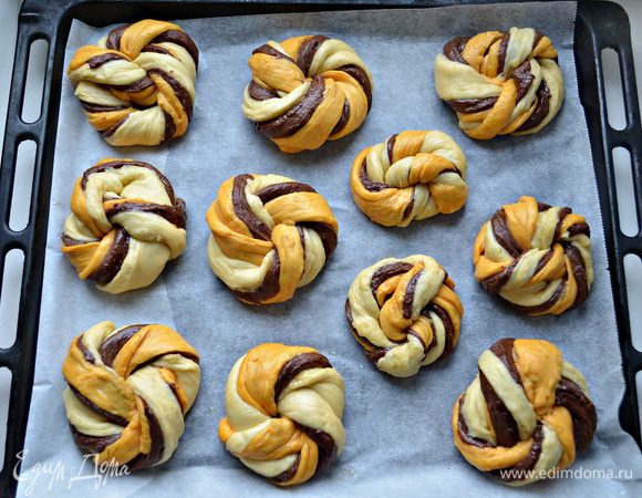 Из скрученной полоски сформируйте булочку. Тоже самое проделайте и со всеми другими полосками. У меня получилось 11 шт, но следующий раз буду делать 12 либо 13, так как в процессе приготовления булочки очень хорошо увеличиваются в объёме. Итак, переложите булочки на противень, выстланный пекарской бумагой и слегка смазанной маслом.