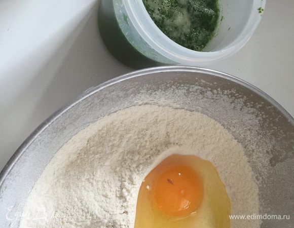 Для начала возьмём весь шпинат и немного буквально несколько минут "поварим" его в небольшом количестве воды. Окрашенную воду сливаем в ёмкость, добавляем туда горсть шпината и пюрируем блендером. Шпинат отставляем пока. В миску просеиваем муку с солью, разбиваем яйцо, начинаем замешивать тесто. Постепенно добавляем шпинатную воду. Нам нужно вымесить мягкое, но достаточно упругое пельменное тесто.