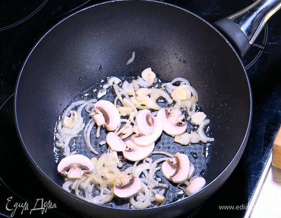 Шампиньоны нарезать пластинками, добавить к луку с чесноком и обжарить.
