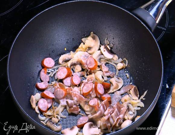 Бекон и колбаску добавить к грибам и немного обжарить.