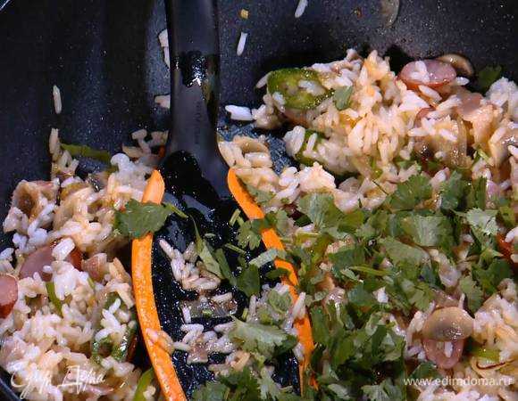 Кинзу крупно порезать, добавить к рису с колбасками, влить сок лайма, перемешать и прогревать все еще пару минут.