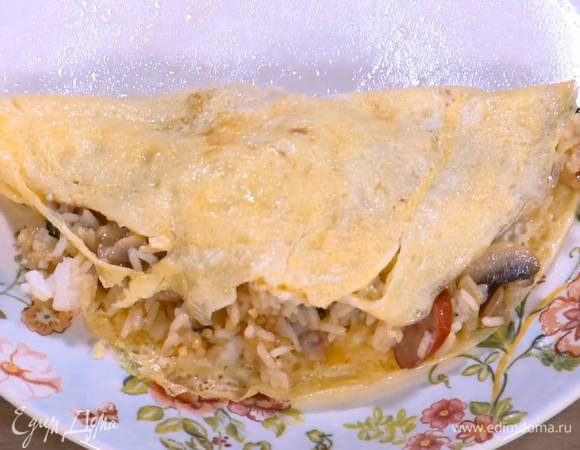 Завернуть в яичные блинчики рис с колбасками и беконом.