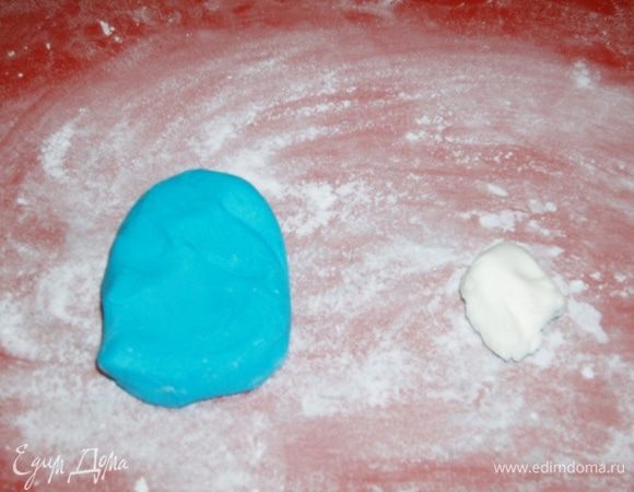 В это время приготовить мастику. Смешать сахарную пудру, крахмал, сухое молоко и сгущенку, замесить как крутое тесто. Я разделила мастику на две части и одну половину смешала с гелевым голубым красителем.