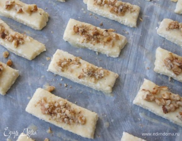 Смазать печенье взболтанным яйцом и присыпать орешками. 