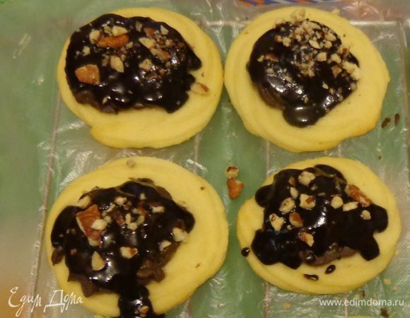 Тем временем сделать ганаш. Растопить шоколад со сливками и сливочным маслом. Охлажденные печенья обмакивать в ганаш. На холодном креме ганаш будет быстро застывать. 