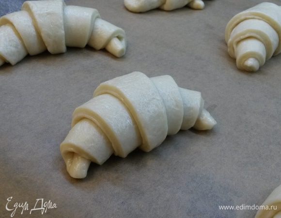 Из каждого треугольника формируем круассан (скатываем тесто рулетом, начиная с широкого конца). Выкладываем круассаны на противень.