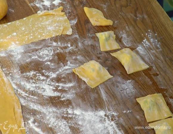 На одну половину теста поместить начинку, выкладывая по одной чайной ложке на некотором расстоянии друг от друга, смазать тесто вокруг начинки белком, накрыть второй половиной теста, скрепить края и ножом разрезать тесто на квадратики с начинкой посередине.